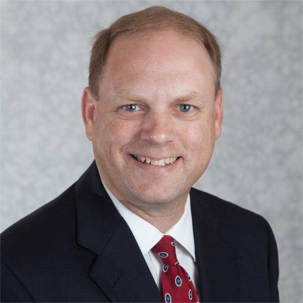 portrait of Tim Born in black jacket and white tie